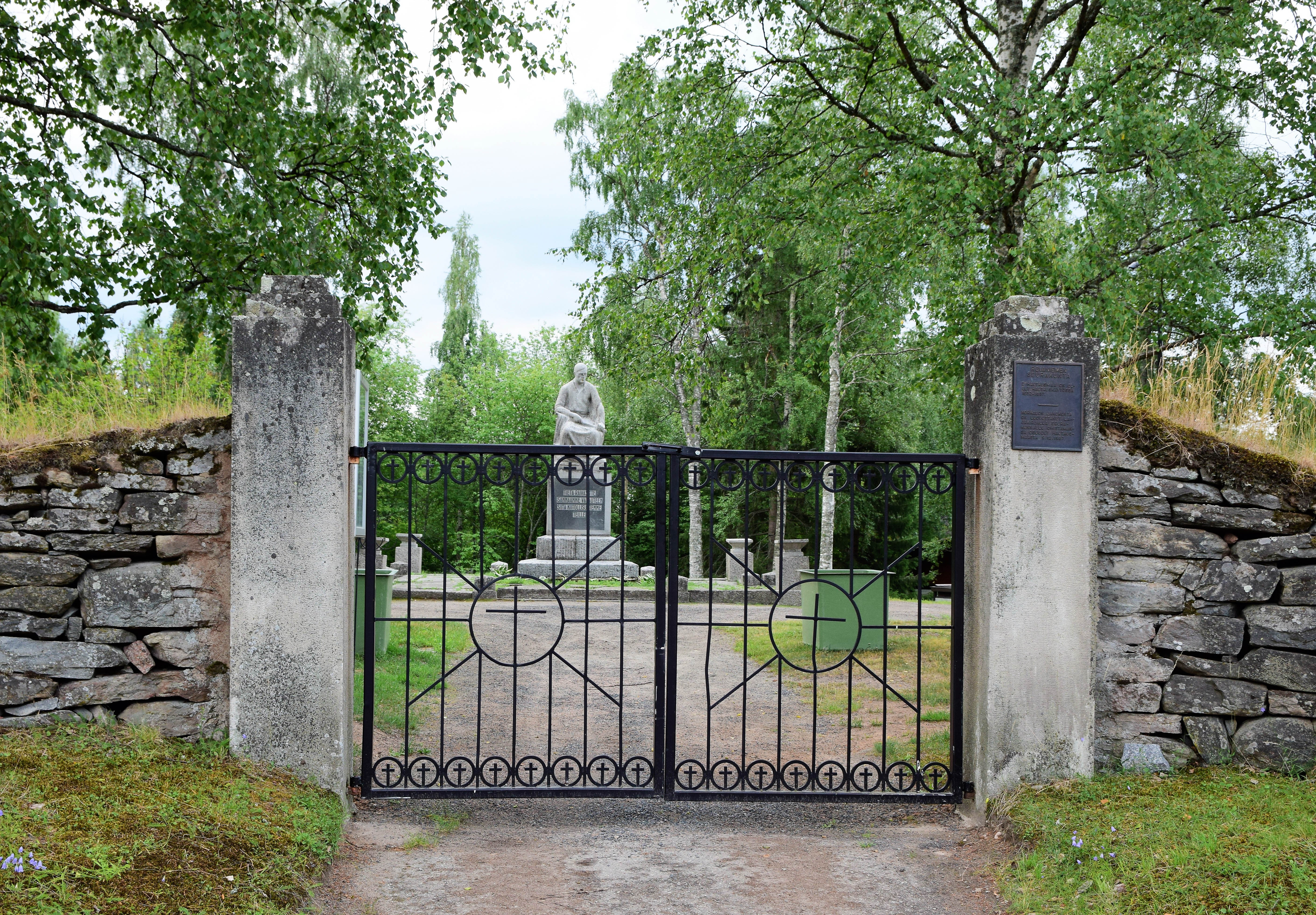 Hautausmaan portti ja muistomerkki.