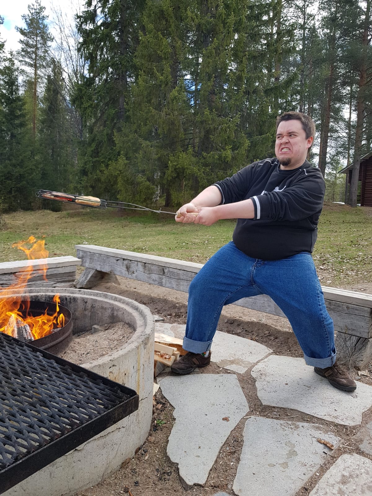 Brouski-nuortenleiri Mies paistaa ruokaa nuotiolla