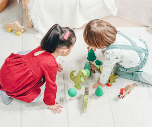 Kaksi lasta leikkii matolla